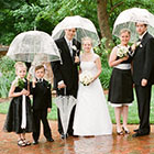 The full bridal party standing for a portrait in the rain
