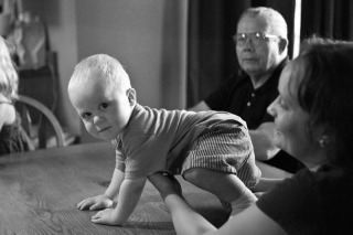 A baby boy crawls on the table