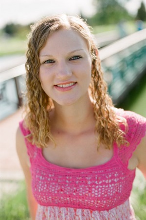 Senior portrait of a young woman in front of a footbridge