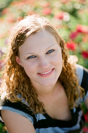 Senior portrait of a young woman with flowers in the background