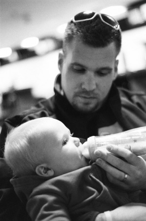 Father feeds his infant son a bottle