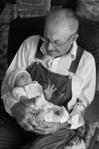 Infant girl being held by her great grandfather
