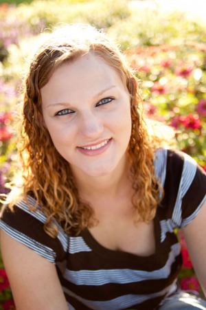 Senior portrait of a young woman sitting in a flower garden