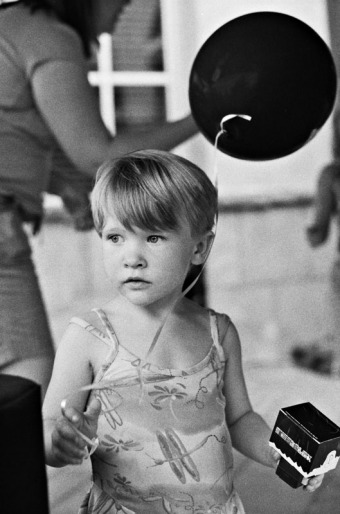 Little girl holding a black balloon