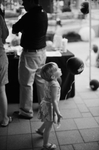 Little girl blowing a black balloon