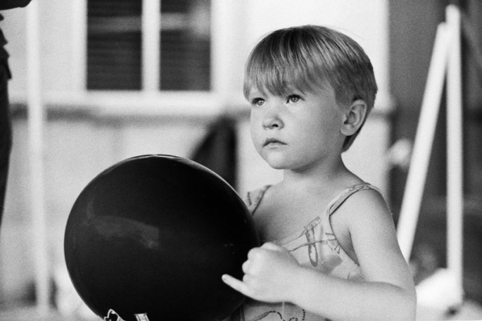 Little girl holding a black balloon