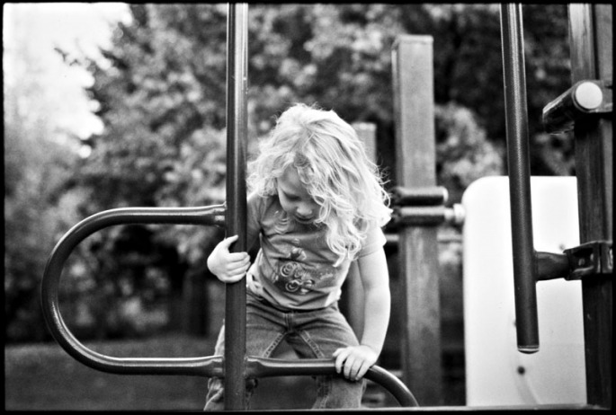 Little girl climbing on playground equipment