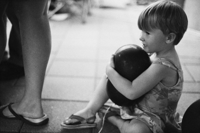 Little girl holding a black balloon