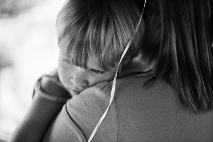 Little girl resting on her mother's shoulder