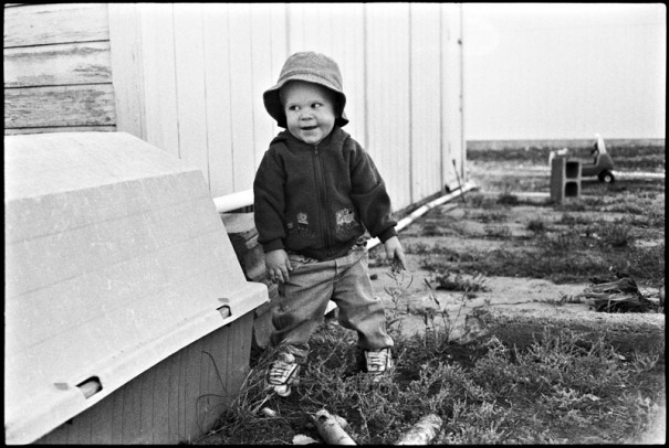 A one year old boy plays outside