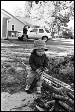 A one year old boy plays with a stick