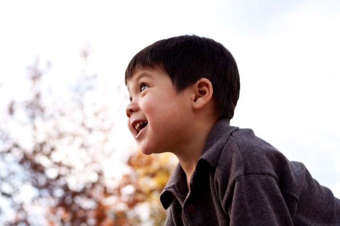 Three year old boy looking up to the sky