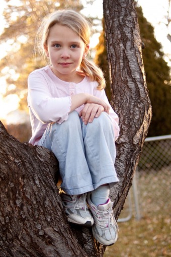 Six year old girl sitting in a tree