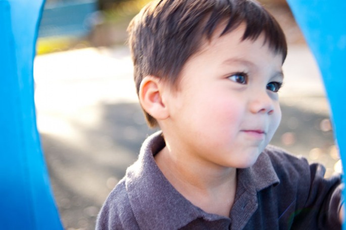 Three year old boy playing on the playground