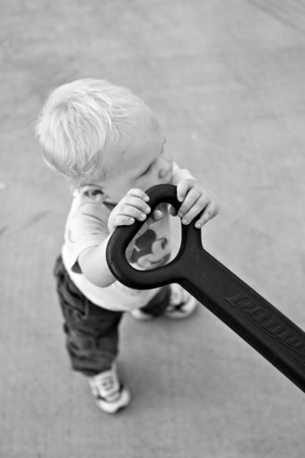 A toddler holds up the handle of his wagon
