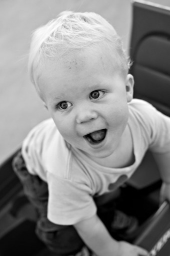 A toddler plays in his wagon