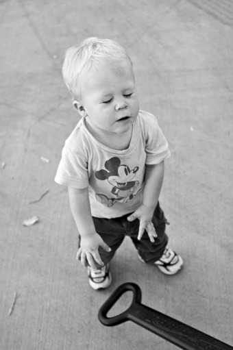 A toddler slams his wagon handle to the ground