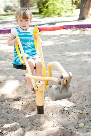 Three year old girl playing on a digging machine