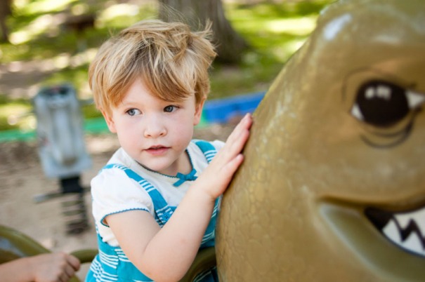 Young girl playing on a dinosaur