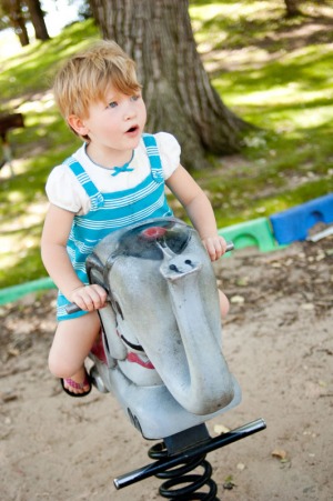 Little girl playing on an elephant