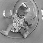 A toddler scoots through a tunnel