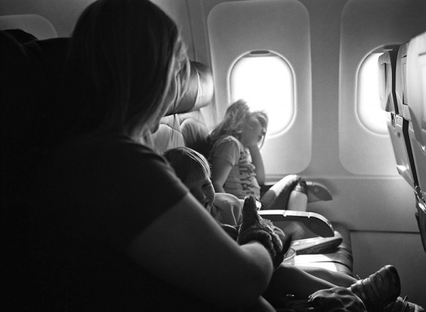 A mother and children sitting on an airplane.