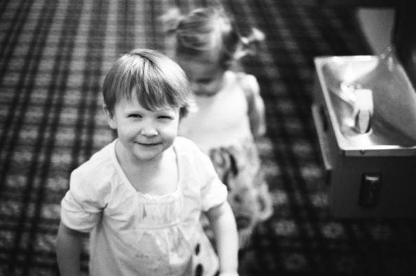 A two year old girl looks suspiciously at the camera. Picture from a hotel reception the night before a Bat Mitzvah in Salt Lake City, Utah.