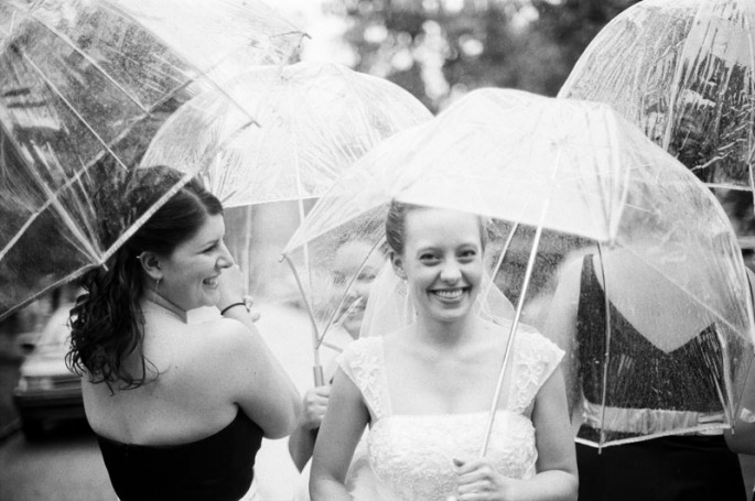 Bride and her bridesmaids standing in the rain
