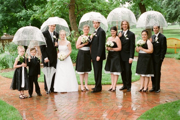 The full bridal party standing for a portrait in the rain