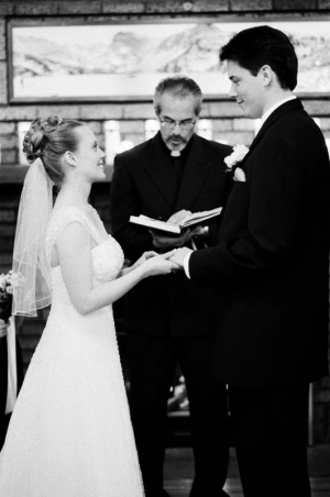 The bride places the wedding ring on the groom's finger