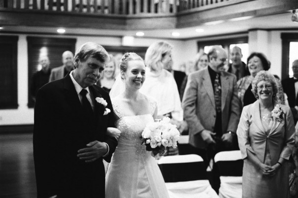 The father of the bride escorts his daughter up the aisle