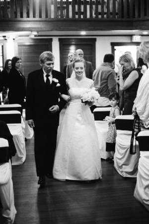 The father of the bride escorts his daughter up the aisle
