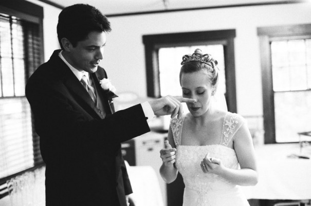 The Groom wipes frosting from the Bride's nose