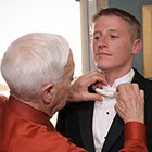 Grandfather adjusts groom's tie.
